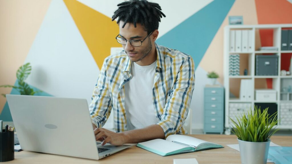 Freelancer radi na laptopu dok upoređuje različite modele online zarade