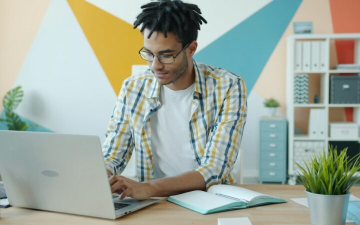 Freelancer radi na laptopu dok upoređuje različite modele online zarade